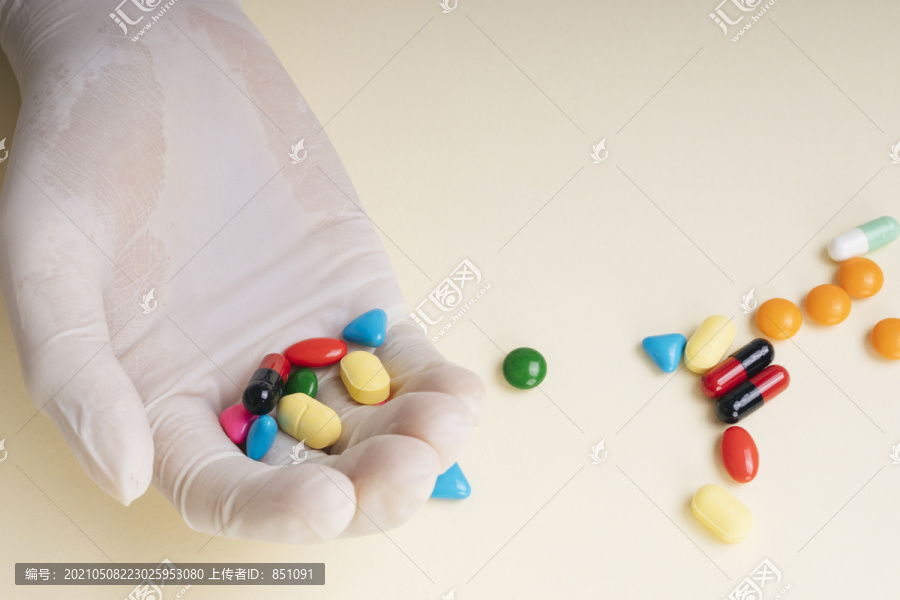 顶视图-医生手套里拿着五颜六色的药丸。