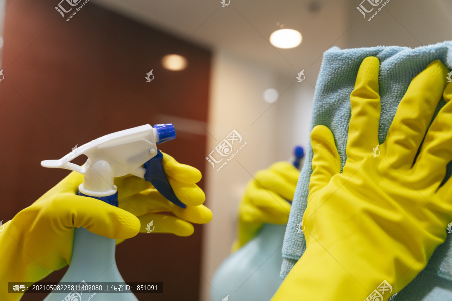 卫生间清洁剂使用喷雾清洁剂瓶和抹布清洁镜。Covid-19冠状病毒预防。