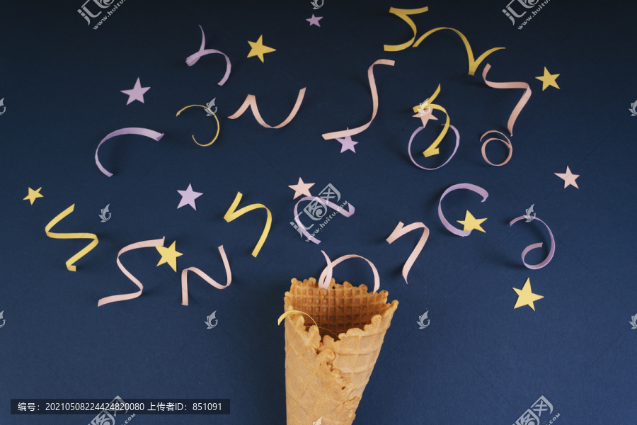 庆祝派对狂欢。有趣的饼干与蛇闪闪发光的节日祝贺和晚会。冰淇淋华夫蛋卷。在深蓝色背景上。