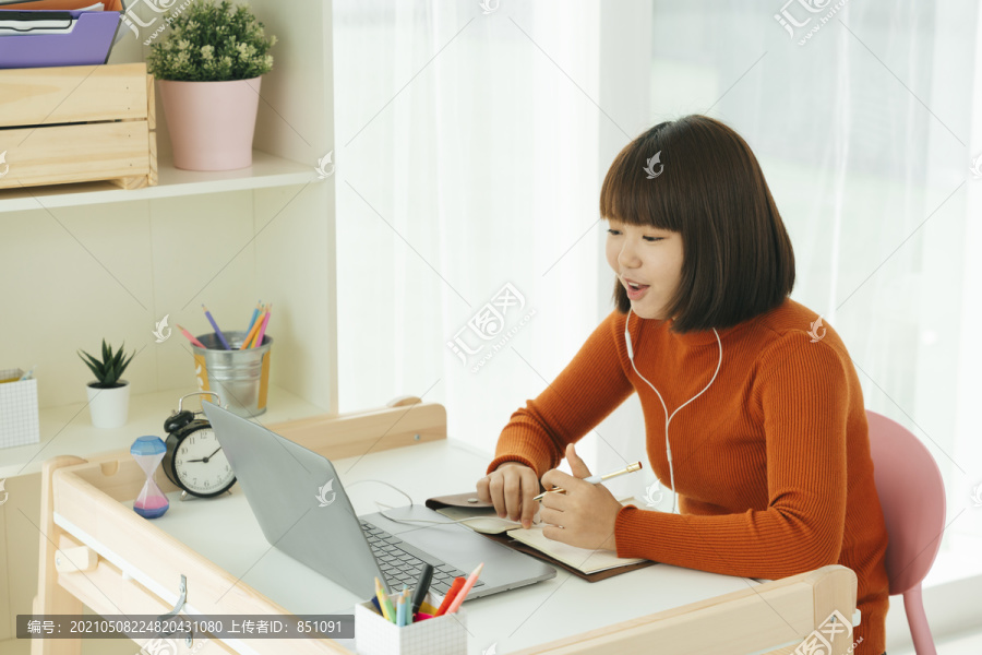 美丽的年轻亚泰黑人短发女子学习从家里学习在线笔记本电脑和戴耳机。