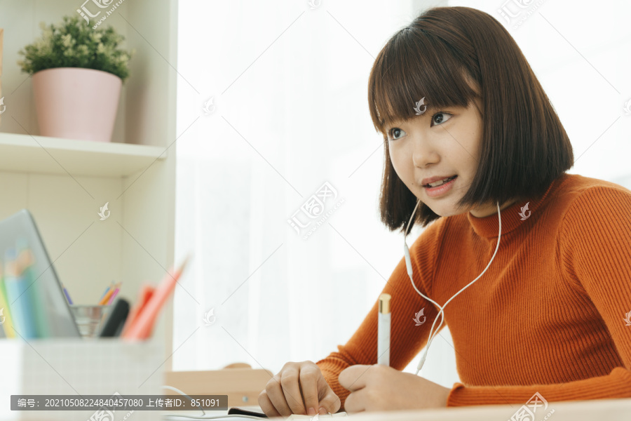 美丽的年轻亚泰黑人短发女子学习从家里学习在线笔记本电脑和戴耳机。