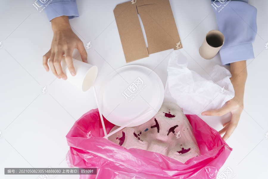 女方亲手将食品包装垃圾放入塑料袋中进行回收处理。