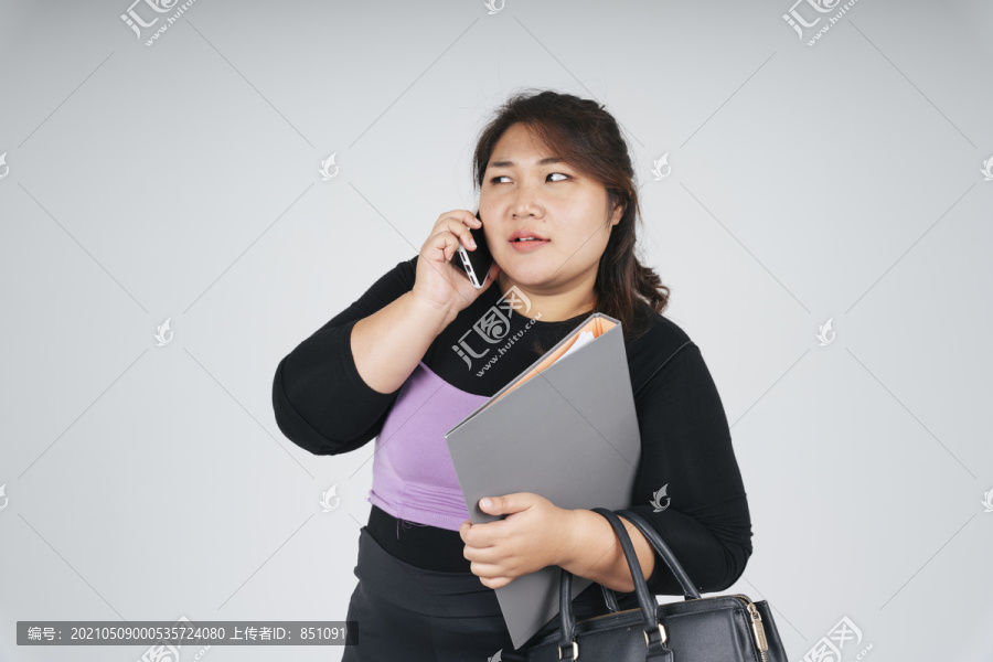 忙碌的亚洲胖乎乎的女商人在白色背景下打电话。