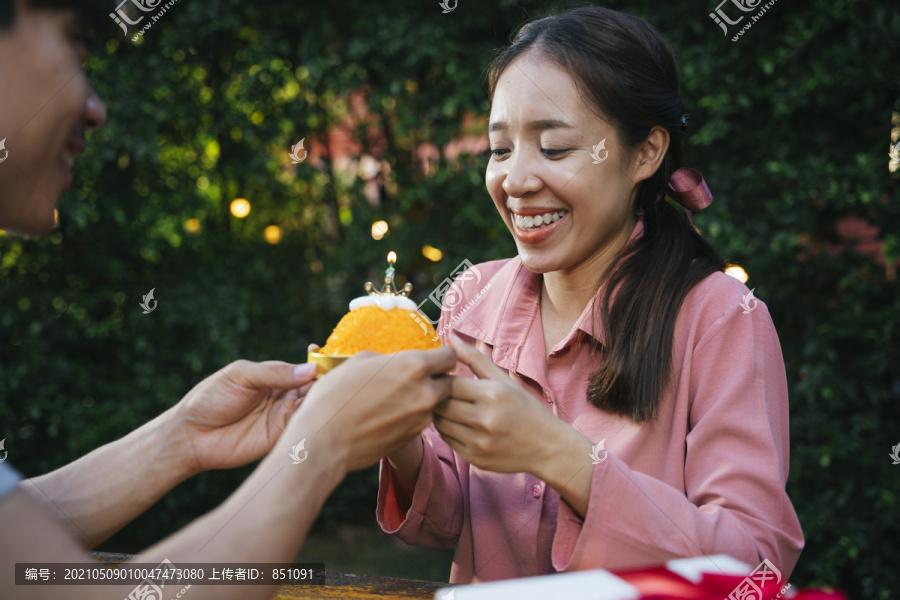 亚洲女人和男友用金线甜点蛋糕庆祝生日派对。