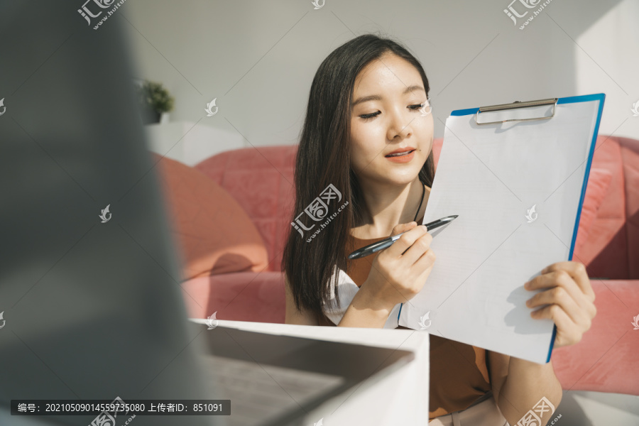 美丽的亚泰女商人在家里笔记本电脑前做财务报告报告。