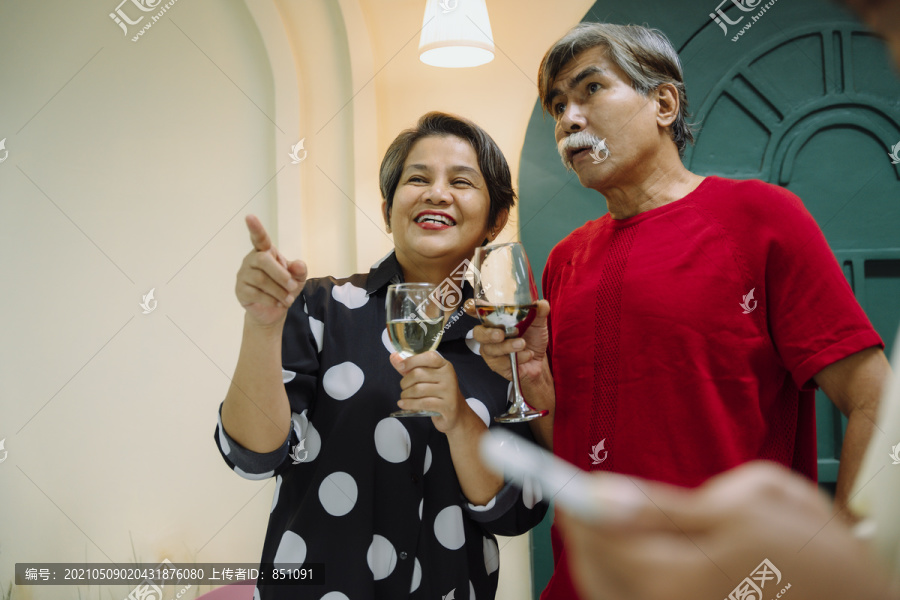 老年夫妇用酒庆祝结婚纪念日的集体肖像。