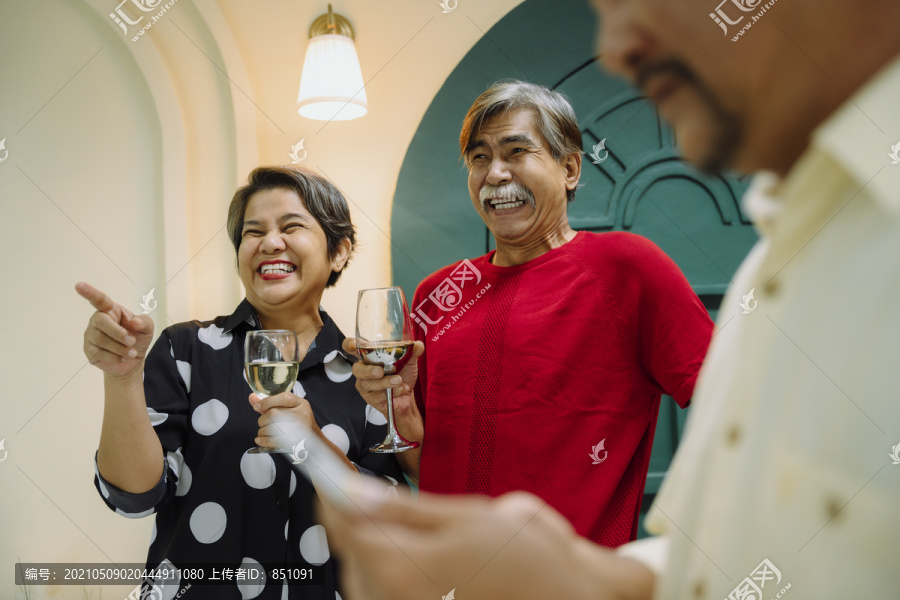老年夫妇用酒庆祝结婚纪念日的集体肖像。