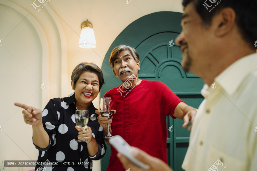 老年夫妇用酒庆祝结婚纪念日的集体肖像。