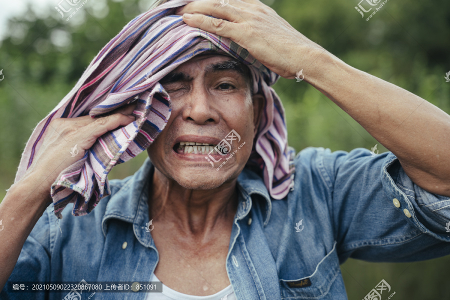 当地亚洲老年农民的特写肖像，头上戴着丝布。