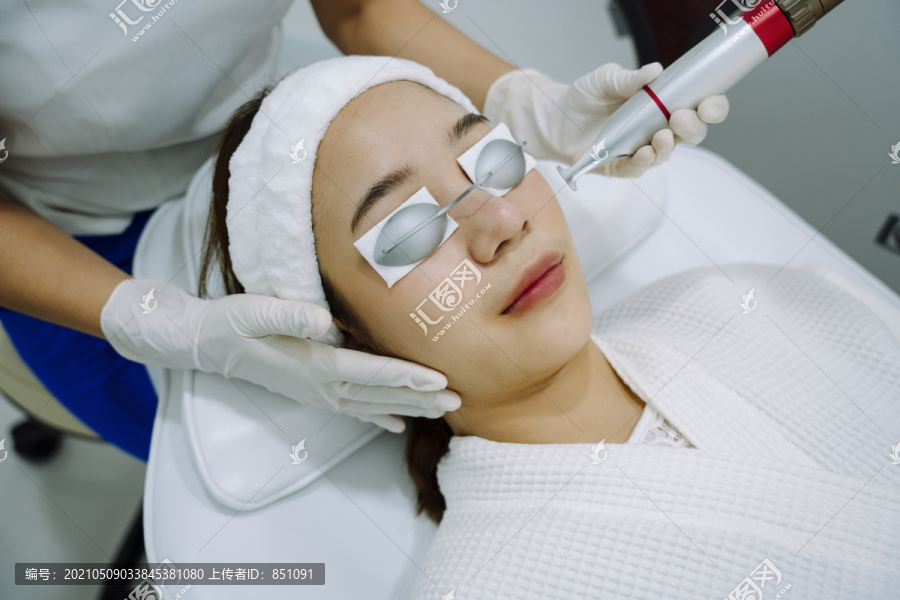 在医学spa中心接受激光和超声波面部治疗的亚洲妇女。