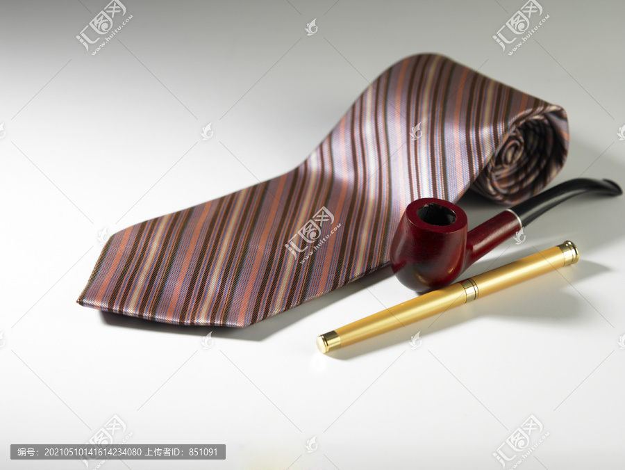 素色背景上的笔筒和领带