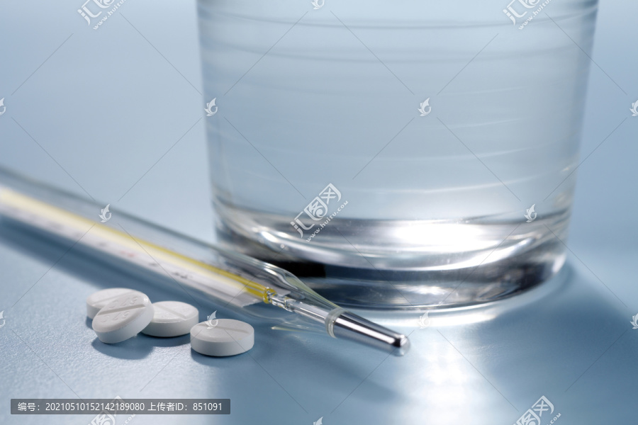 阿司匹林药片，体温计和一杯水