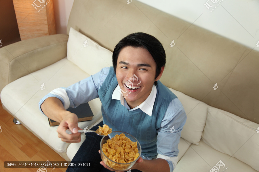 微笑的男人在吃一碗麦片