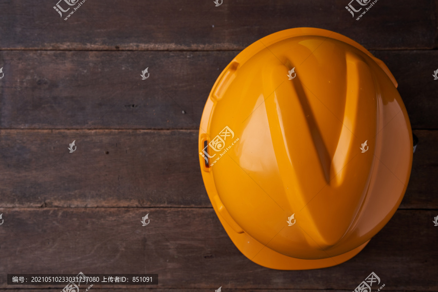 安全帽。木制背景上的黄色建筑头盔。