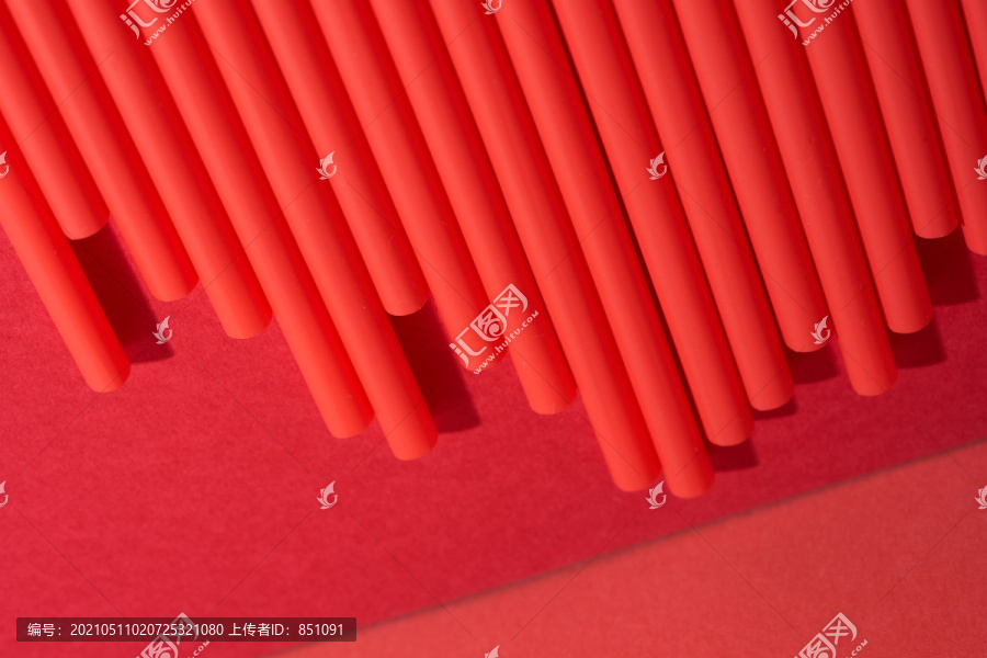 一排排红色塑料吸管排列成红色背景上的图形