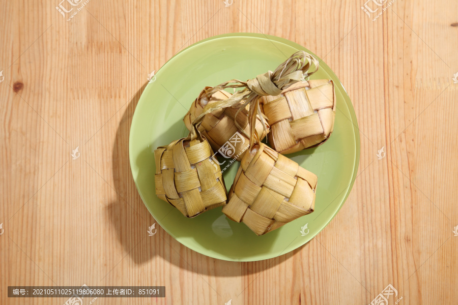 木制背景上的饺子。Ketupat是一种天然米壳，由年轻的椰子叶制成，用于在穆巴拉克开斋节期间煮饭