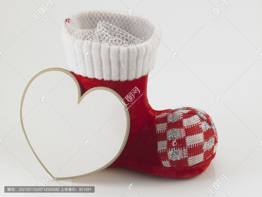 圣诞老人的靴子或鞋子，白色背景上有心形卡片