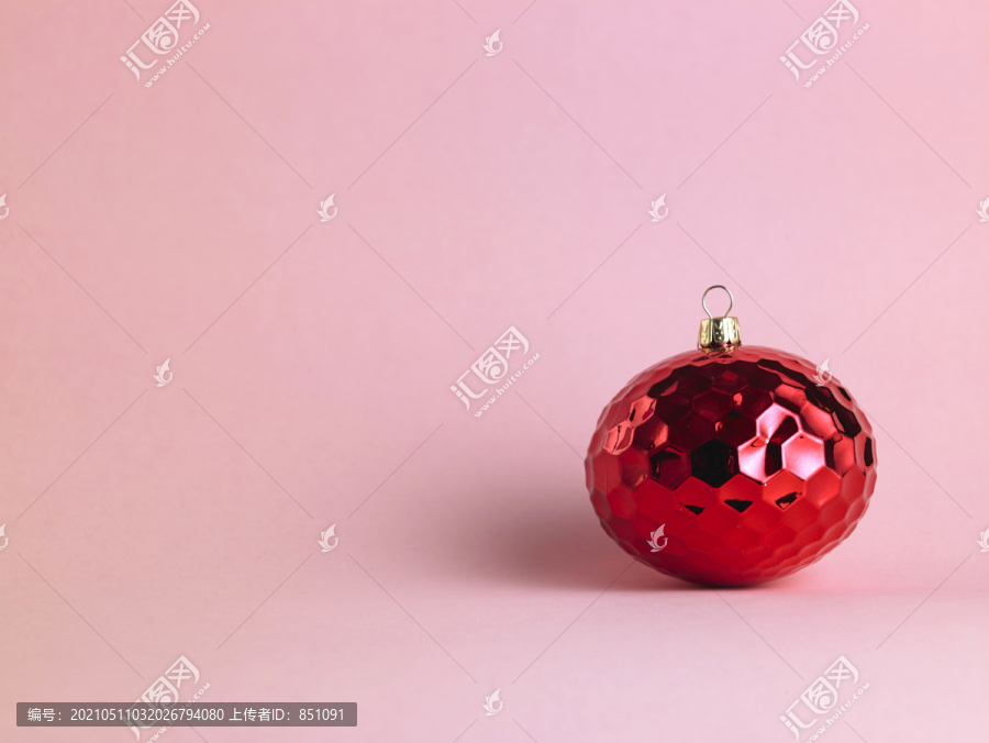 粉红色背景上的红色圣诞装饰品