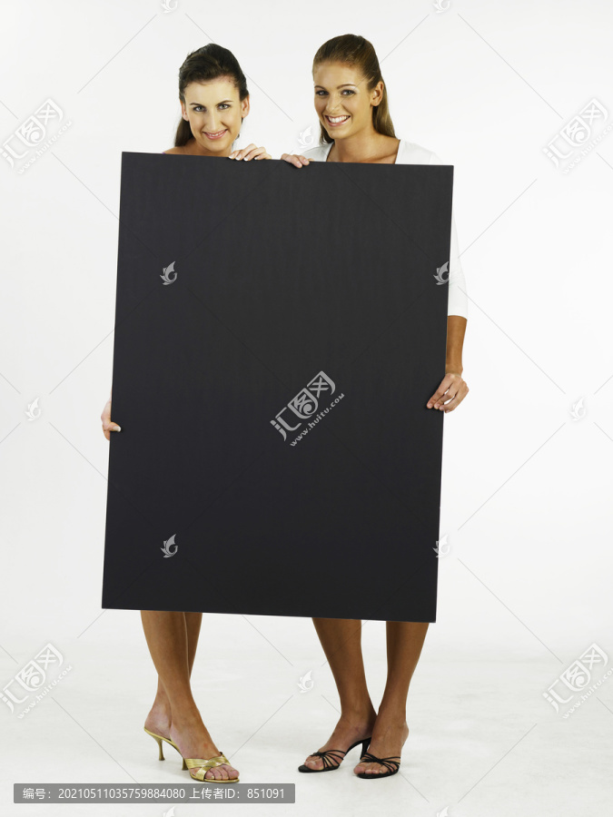 两个女人拿着一张大号的卡片