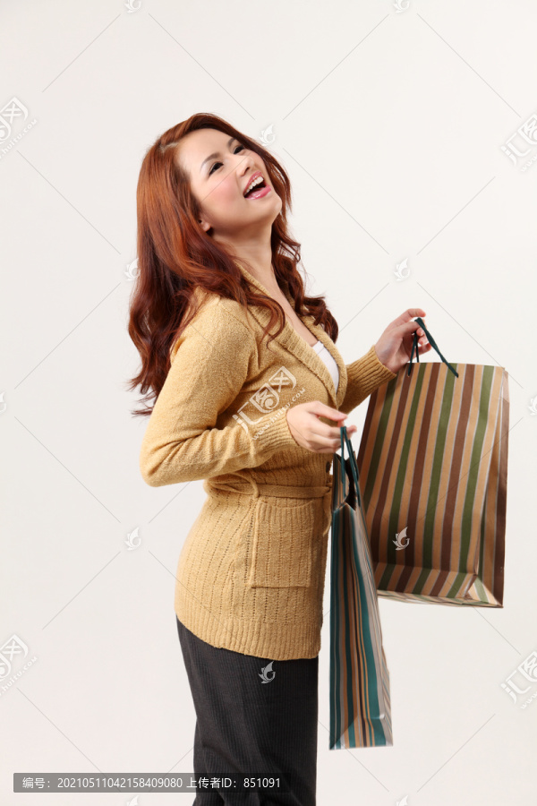 女人拿着购物袋，微笑着