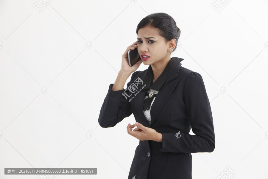 这个女人在用手机说话时感到很难过。一个悲伤的年轻女人。