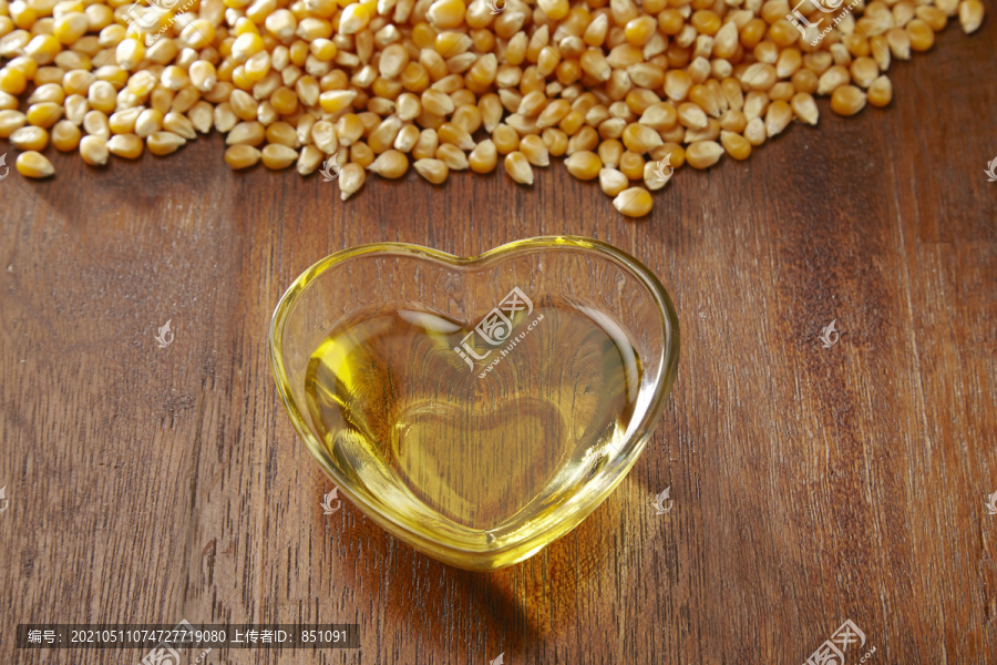 玉米和装满玉米油的心形容器玻璃