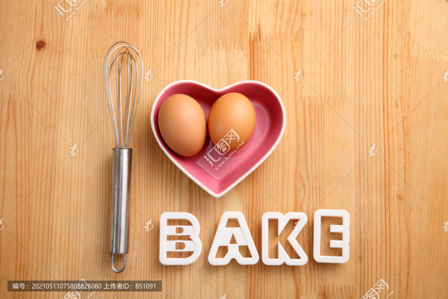 烘焙概念手搅打旁边的鸡蛋在一个心形容器