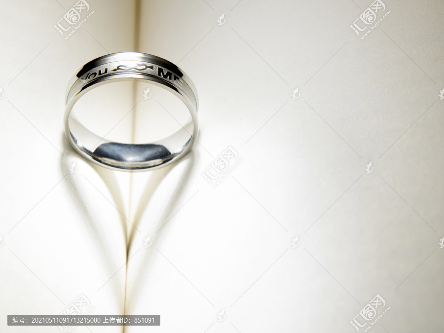 结婚戒指在书上投下心形的影子