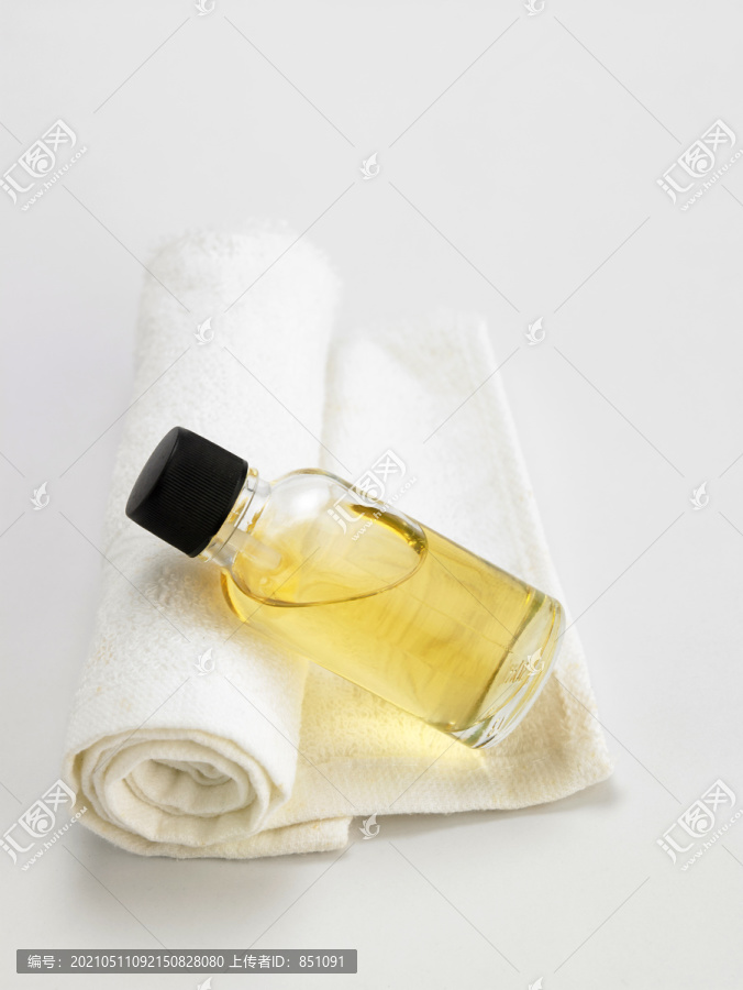在毛巾上放一瓶按摩油