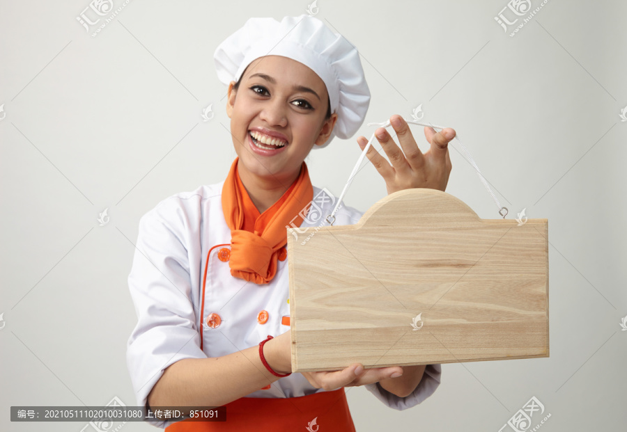 穿着厨师制服的印度女人拿着一块木板