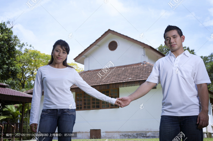 一对夫妇手牵手在屋前