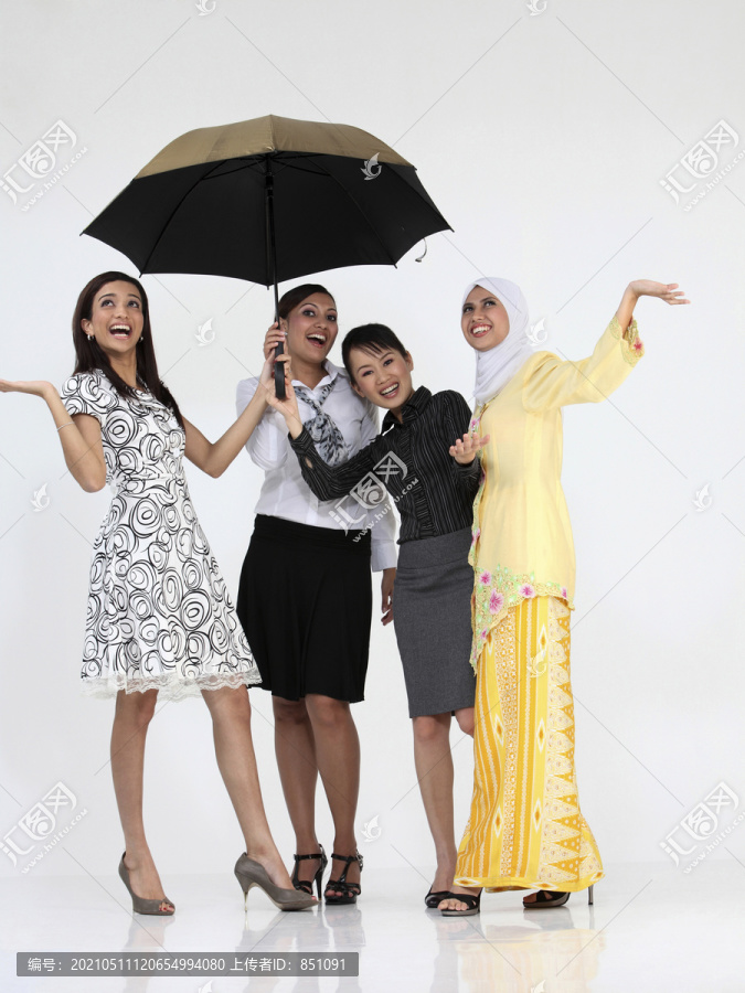 多种族妇女手持雨伞在镜头前合影