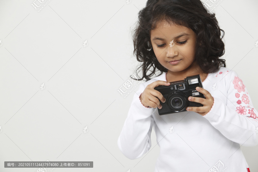 年轻女孩在检查她的相机