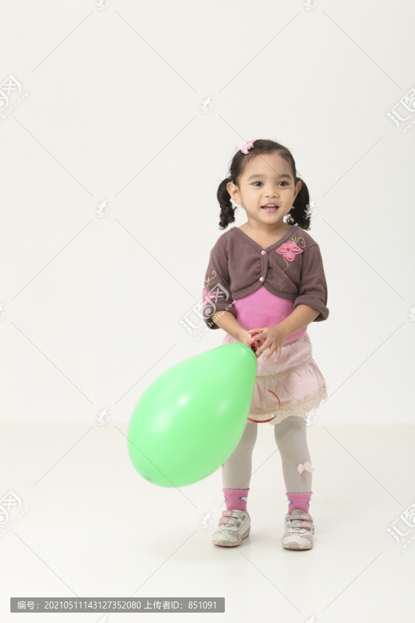 手持绿色气球的马来女孩