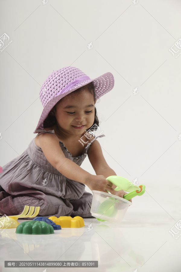女孩玩沙滩玩具的摄影棚照片