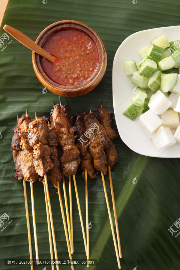 马来西亚食物沙爹的俯视图，香蕉叶上有黄瓜、洋葱和烤羊肉