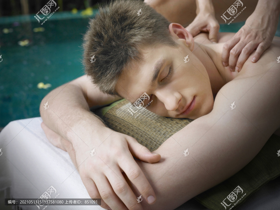 男士在泳池边放松享受香薰按摩