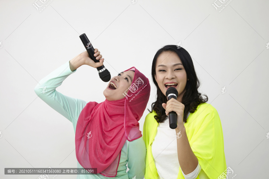 两个穿着五颜六色服装的女人在唱歌