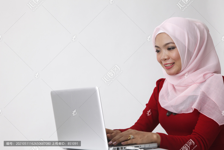 坐在笔记本电脑前的马来妇女
