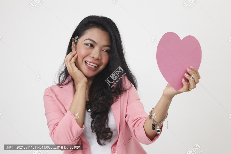 马来妇女拿着一张心形的纸，上面写着疑问