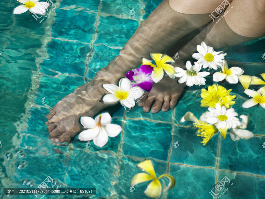 在温泉池里用花泡脚的女人