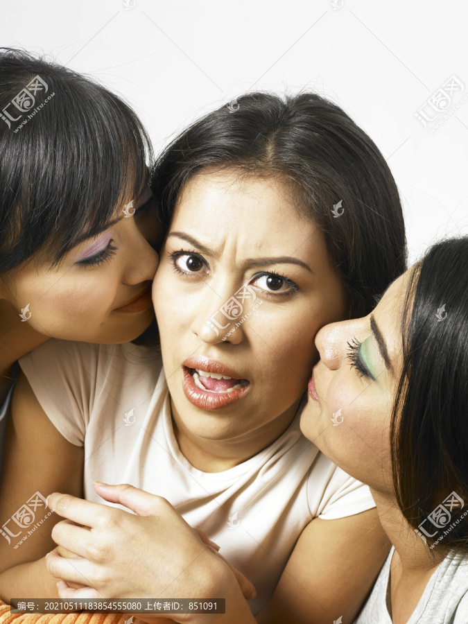 被两个朋友亲吻脸颊的女人