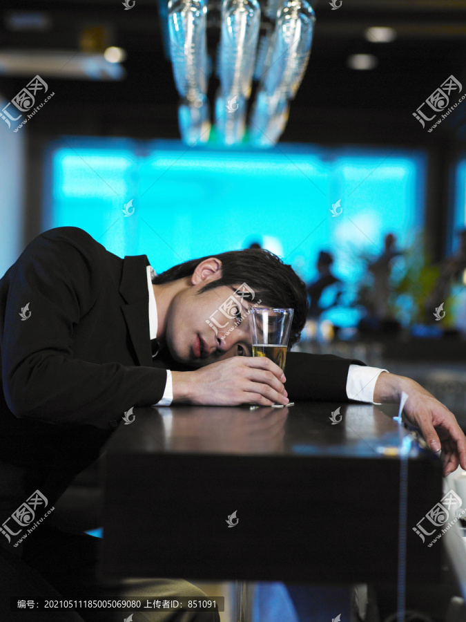 疲倦的商人在吧台喝酒