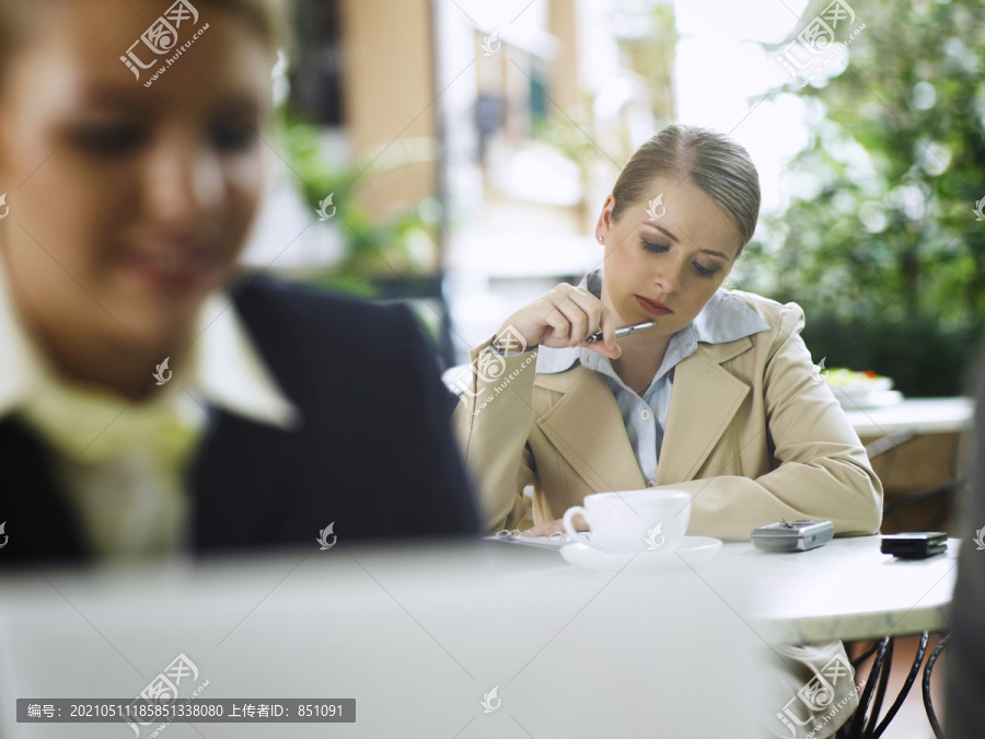 两位商务女性坐在咖啡馆外的选择性聚焦