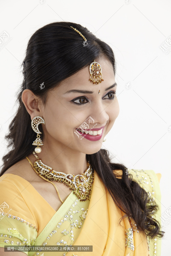 一位美丽的印度年轻女子的面部特写肖像，她热情友好的微笑