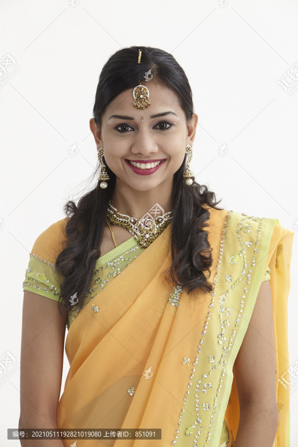 一位印度妇女的正面照片，她露出了露齿的微笑