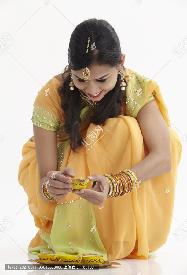印度妇女，穿着迷人的传统服装，手持油灯