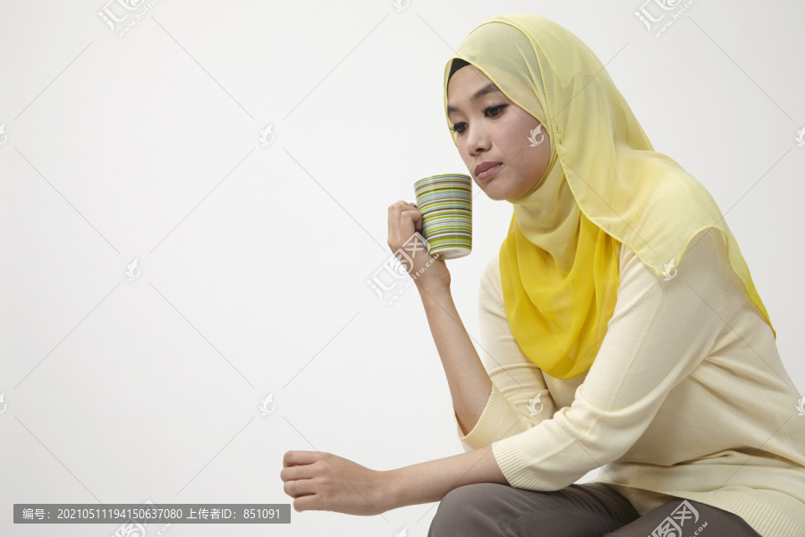 马来女人端着一杯茶放松