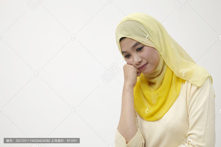 在白色背景下孤独地低头思考的马来女人