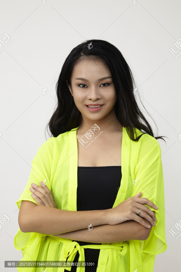 白人背景下的亚洲女性。穿着黄色衬衫的中国女人微笑着看起来很开心
